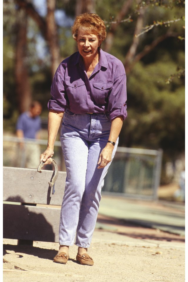 Woman throwing horseshoe at outdoor event