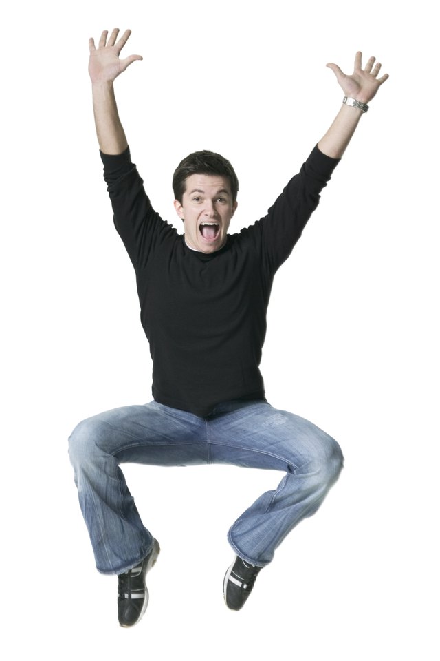 full body shot of a young adult male in a black shirt as he jumps through the air