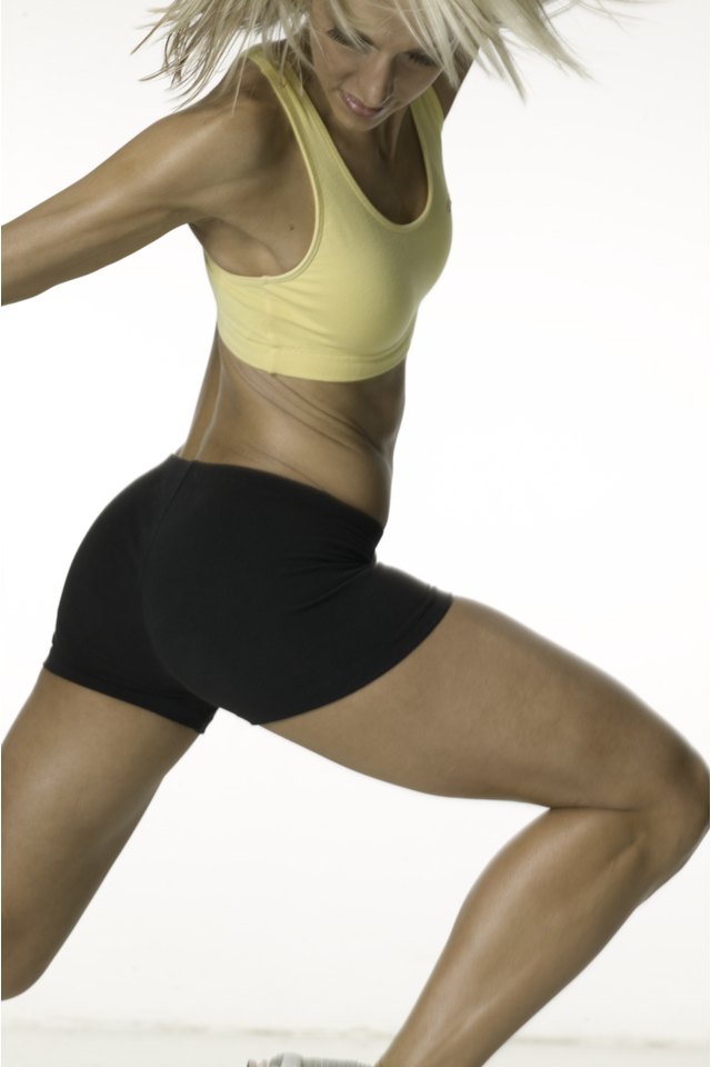 Young woman with slim figure, jumping in studio, portrait