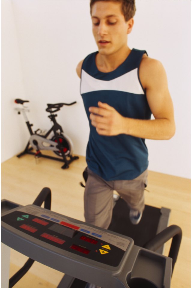 Close-up of a young man jogging on a treadmill