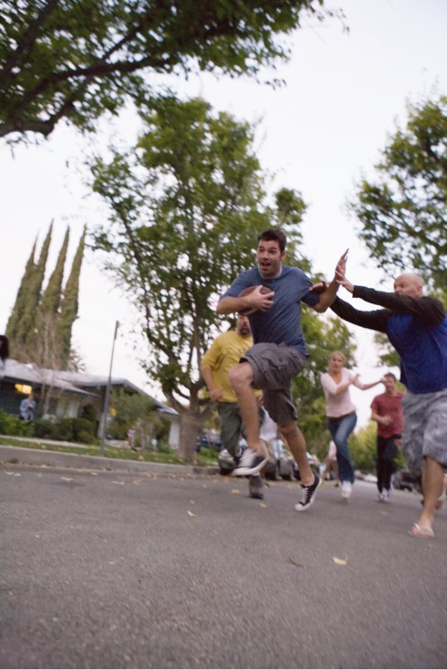 Group of friends playing football in street