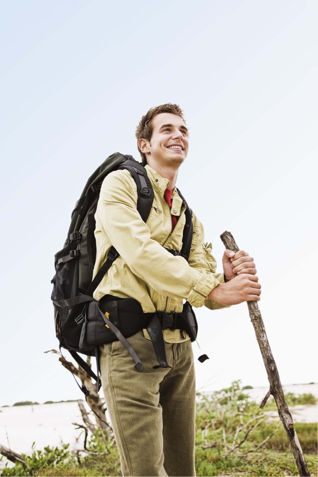Hiker with backpack standing by swamp