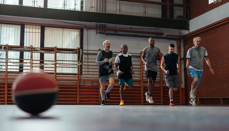 People warming up on basketball court.