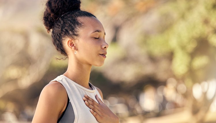 Black woman, breath and hand on chest, for meditation and wellness being peaceful to relax. Bokeh, African American female and lady outdoor, in nature and being calm for breathing exercise and health