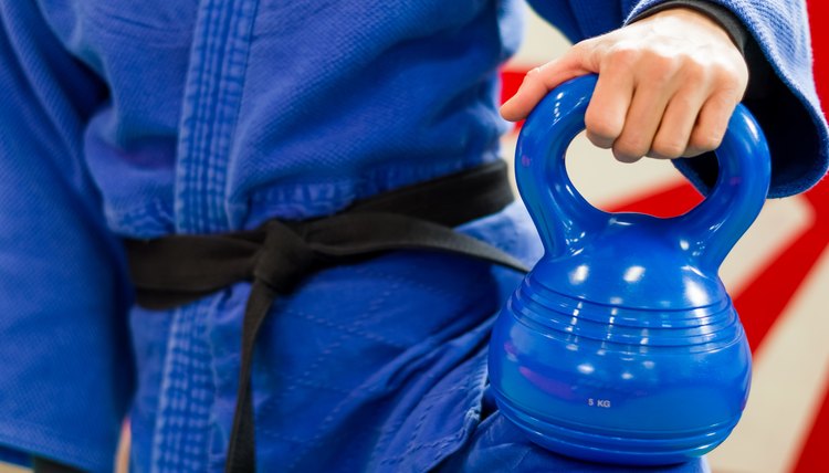 Close Up of Woman in Blue Judo Gi, and Black Belt, which is Train with weights and kettlebells Girya
