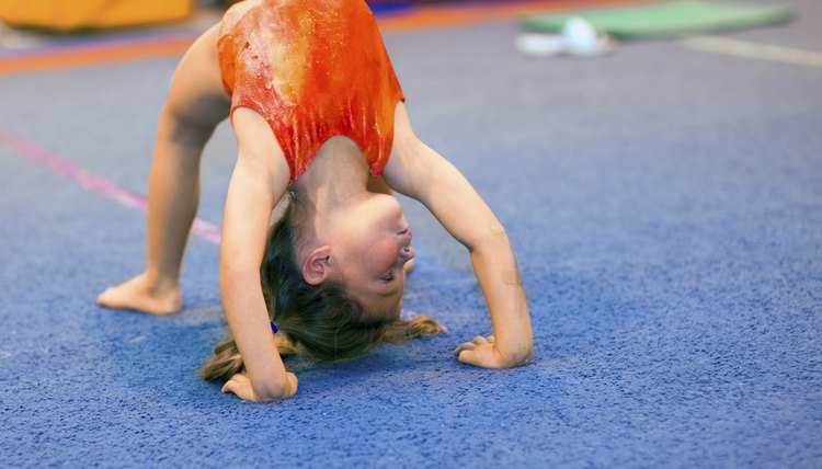 Toddler girl in leotard doing a bridge