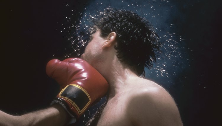 Sweat flying from boxer's head from force of punch
