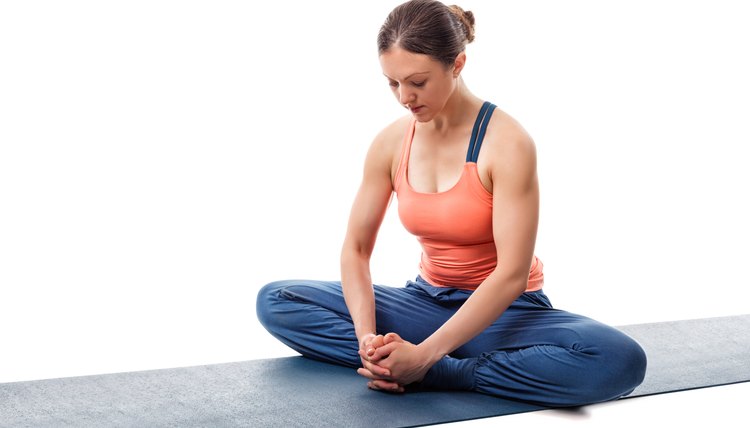 Woman practices yoga asana Baddha konasana