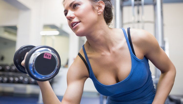 Determined woman lifting dumbbell weight