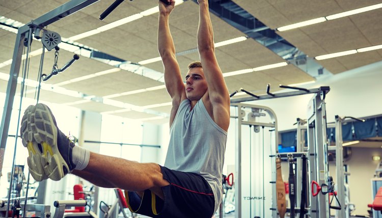 man flexing abdominal muscles on pull-up bar