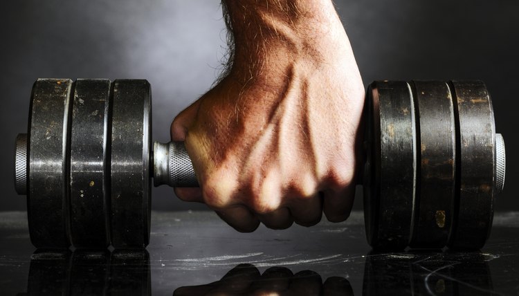 male hand is holding metal barbell