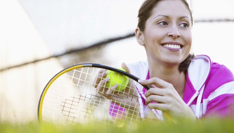Woman with tennis equipment on grass
