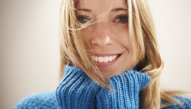 Young woman, hands under chin with wind in hair