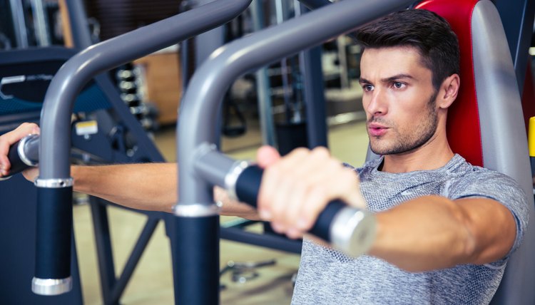 Man workout on fitness machine in gym