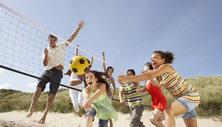 Group Of Teenage Friends Playing Volleyball On Beach