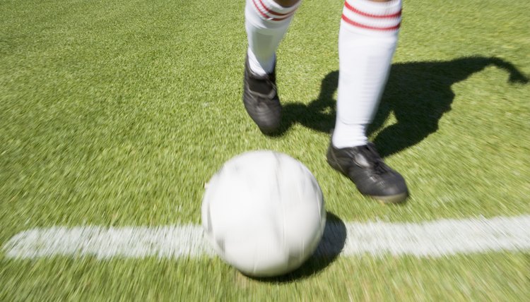 Feet kicking soccer ball