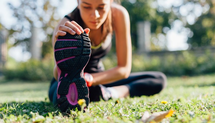 Young woman doing some warm-up exercises before running.
