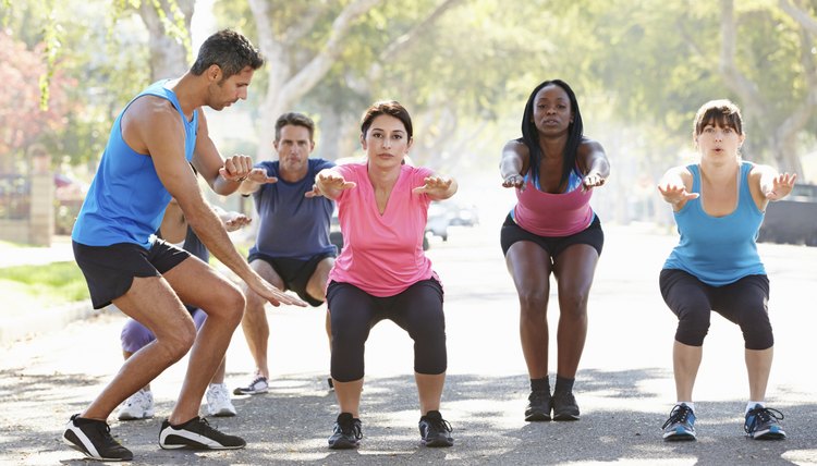 Group Of People Exercising Street With Personal Trainer