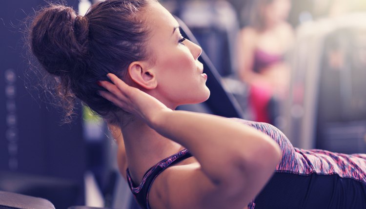 Picture of fit woman doing sit ups in gym
