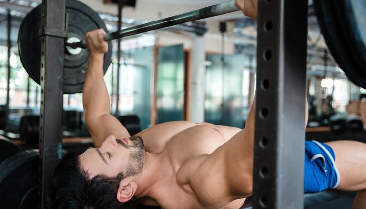 Handsome male bodybuilder doing bench press