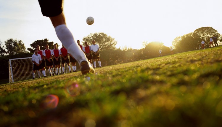 Soccer player kicking ball towards goal, ground view