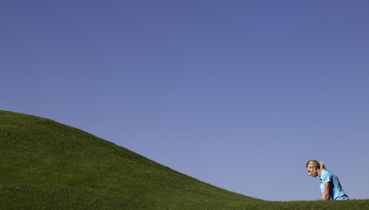 Woman playing golf, side view