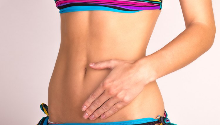 Young woman in bikini touching her stomach