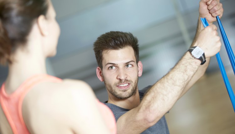 Couple training in fitness studio with resistance band