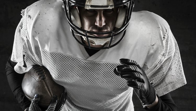 Portrait of american football player holding a ball and running