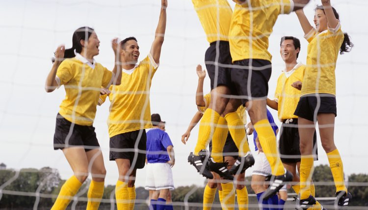 Mixed Football team celebrating goal at goal mouth, surface view