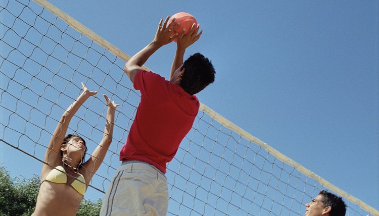 Teenagers playing volleyball outdoors