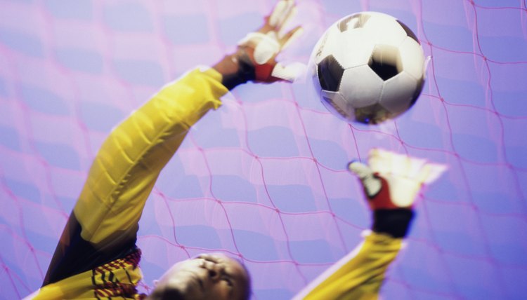 Low angle view of a goalie catching a ball