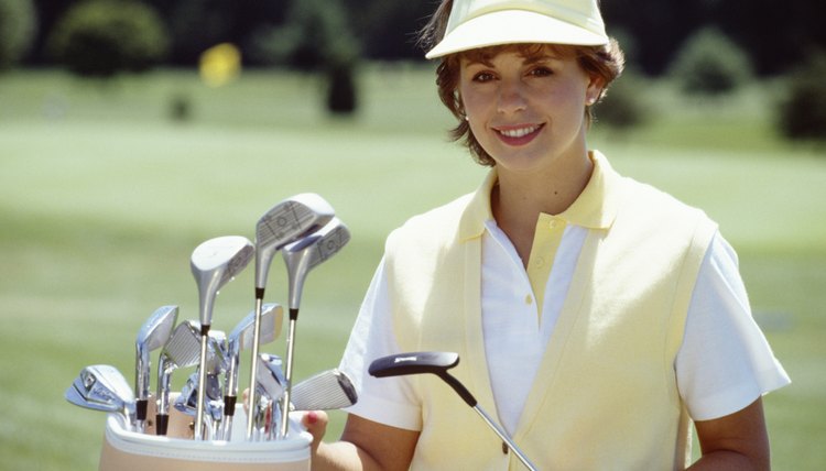 Portrait of woman posing by bag of golf clubs