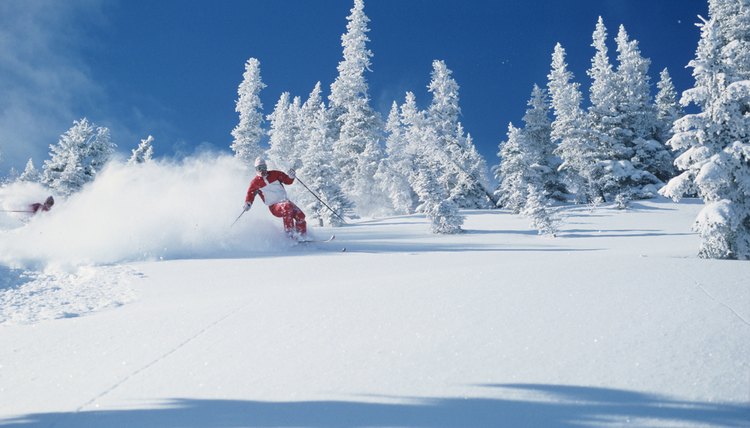 Lone skier riding through powder, British Columbia, Canada