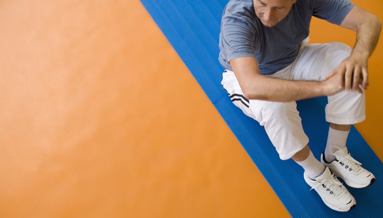 Man sitting on exercise mat