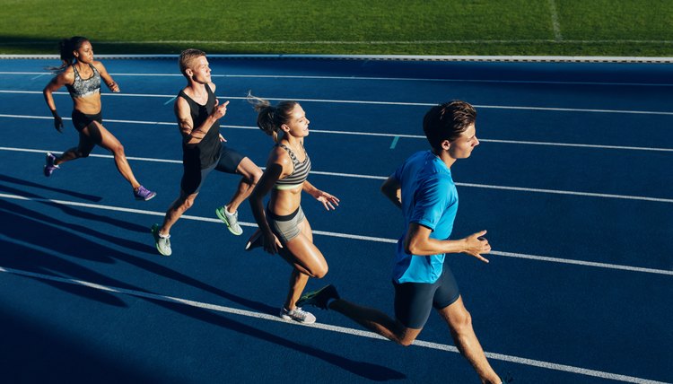 Multiracial athletes practicing running on racetrack