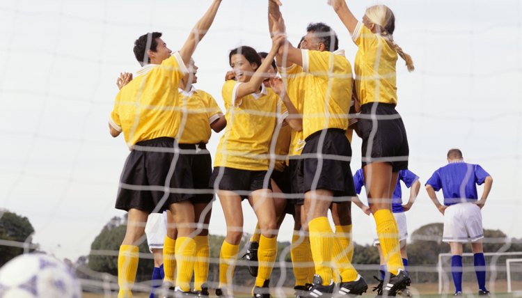 Mixed Football team celebrating goal at goal mouth, surface view
