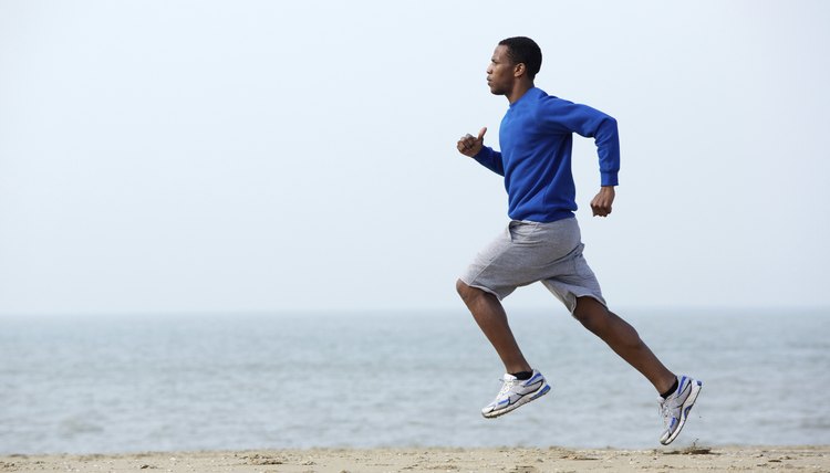 Young athletic man running at the beach
