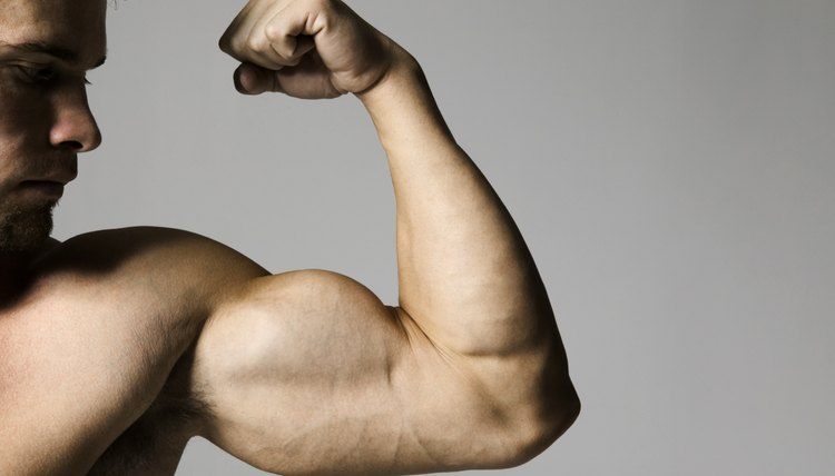 medium shot of a muscular male as he flexes his bicep