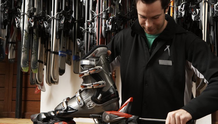 Young man checking boots, skis and bindings in sports shop