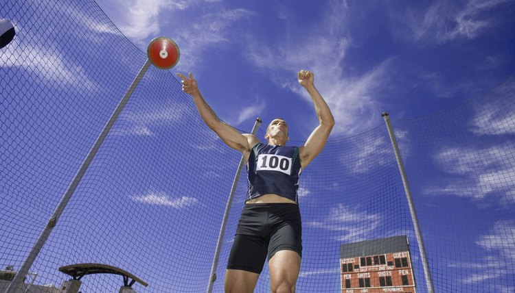 Male athlete throwing discus, low angle view