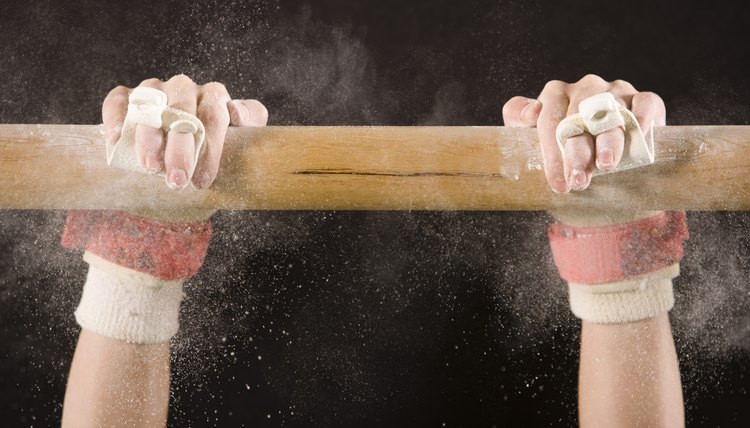 Hands of gymnast hanging on bar