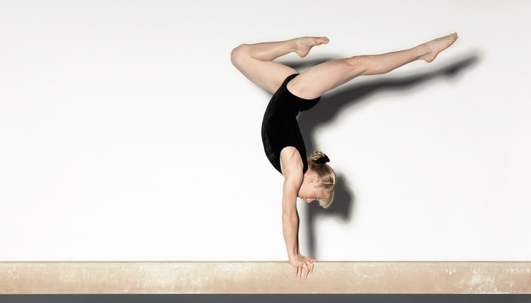 Young Gymnast Doing Handstand on Balance Beam