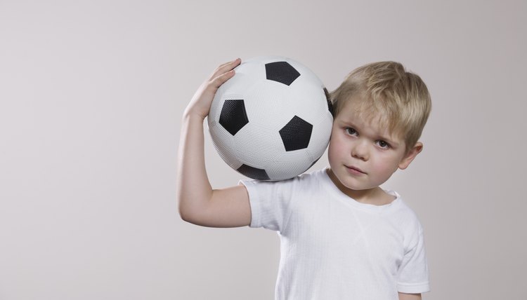 Boy holding soccer ball, portrait